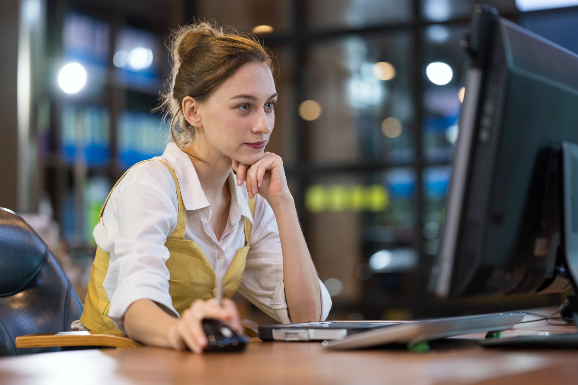 Young woman working on a laptop. IoT Solutions to Increase Your Business Productivity.  Mid adult woman working at desk in a business office while reviews or access business strategy and planning. | © Nitat Termmee @getty