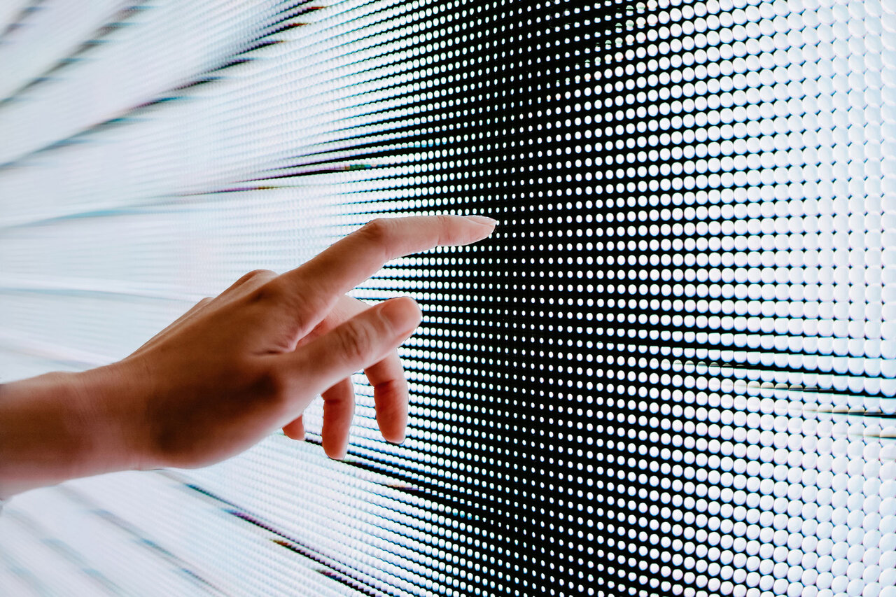 Close up of woman's hand touching illuminated LED display screen, connecting to the future | © d3sign @GettyImages