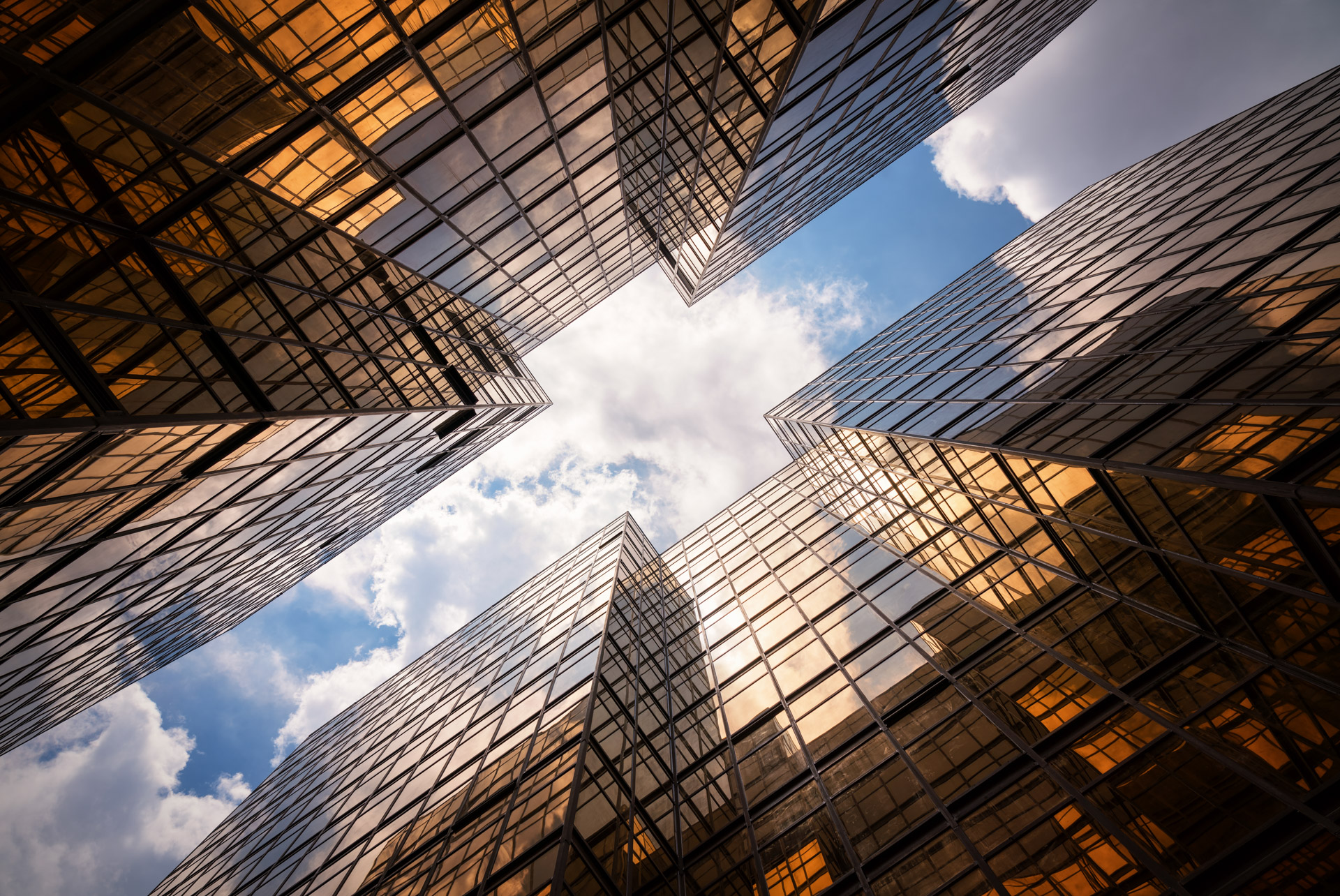 Skyscrapers seen from below with blue sky with clouds between them | © Kanchisa Thitisukthanapong @Getty