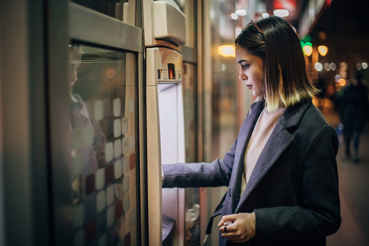 Beautiful young woman using ATM machine | © Hirurg @Getty