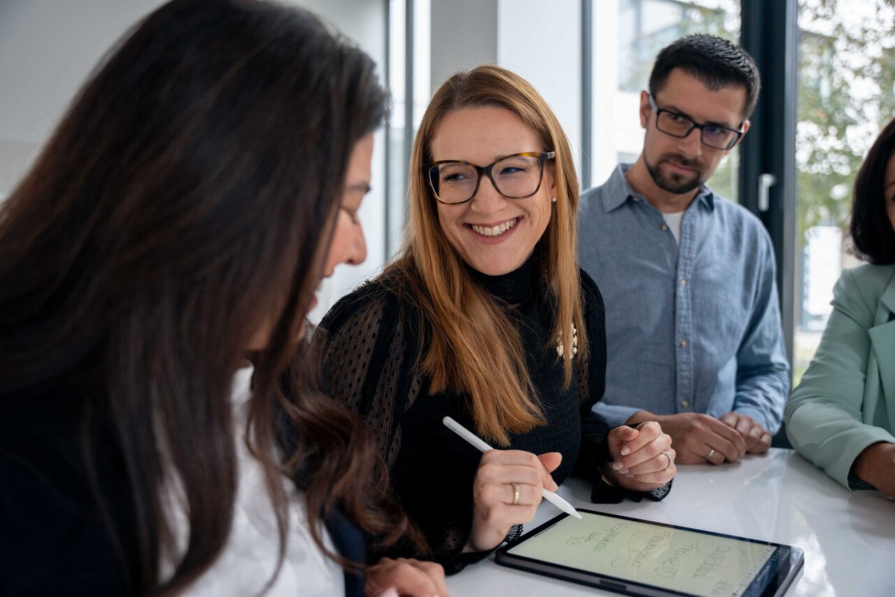 Sopra employeees working together on an iPad